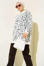 Pull à col roulé blanc avec motif léopard et détails à poils