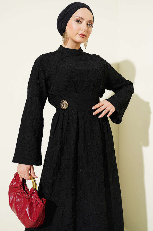 Robe noire avec ceinture brodée, pince et accessoire doré