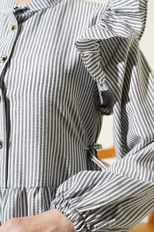 Robe noire à rayures en seersucker, à volants aux épaules et boutons.