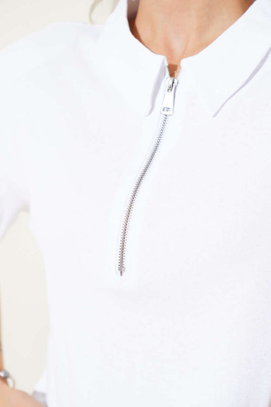 Wit T-shirt met schoudervullingen en ritssluiting.