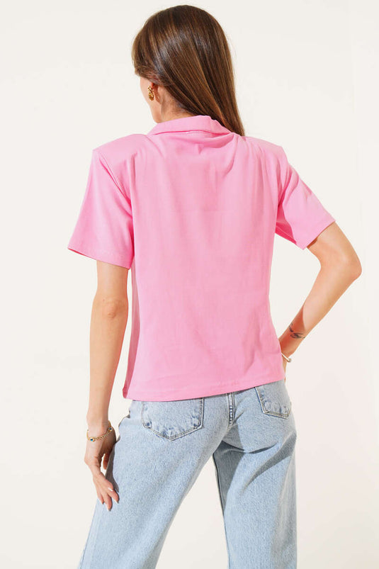 Roze T-shirt met schoudervullingen en ritssluiting.