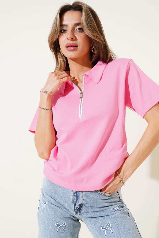 Roze T-shirt met schoudervullingen en ritssluiting.