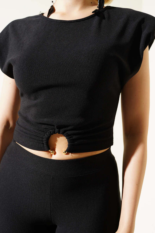 Combinaison courte noire avec épaulettes rembourrées et boucle détaillée