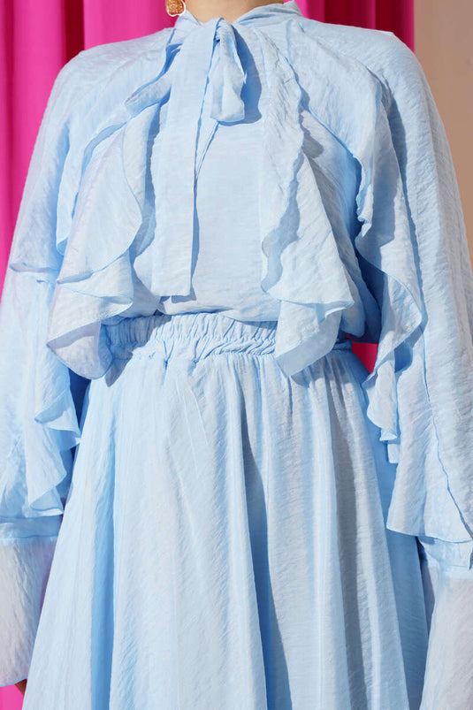 بدلة من قطعتين مع تفاصيل الكشكشة وتنورة باللون الأزرق