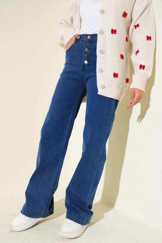 Jean en denim bleu à jambes larges avec boutons métalliques sur le devant.