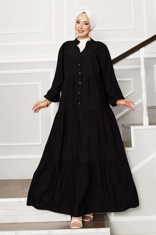 Robe noire à demi-boutons superposés sur le devant