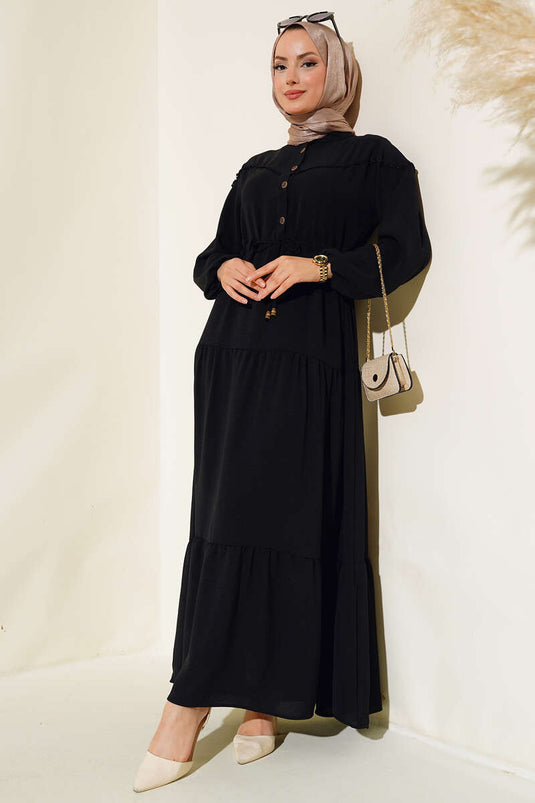 Robe noire à demi-boutons superposés sur le devant