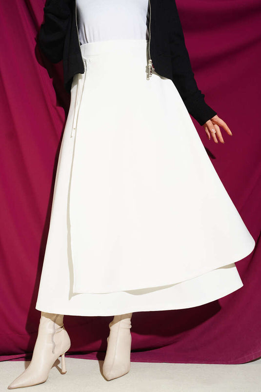 تنورة سكوبا مزينة بتفاصيل القطع ومرتبطة بلون عاجي