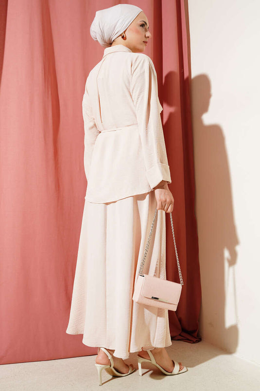 Ensemble Ayrobin beige avec détails patchwork et jupe ceinturée.