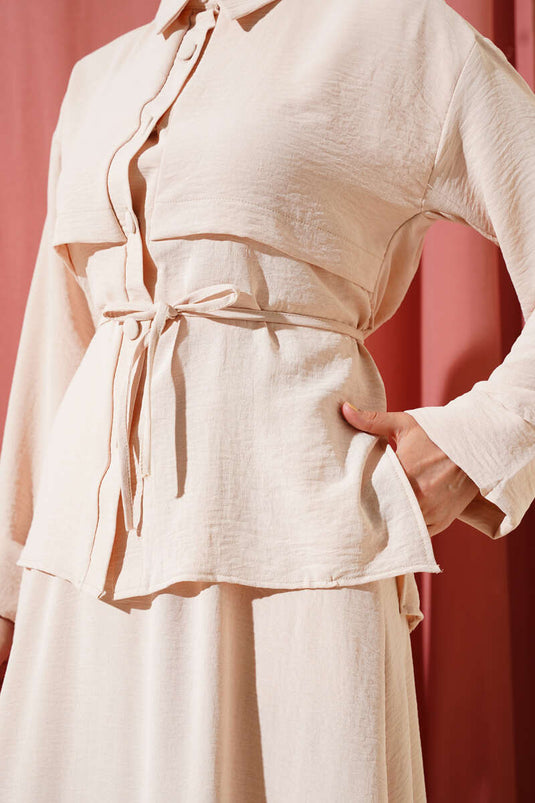 Ensemble Ayrobin beige avec détails patchwork et jupe ceinturée.