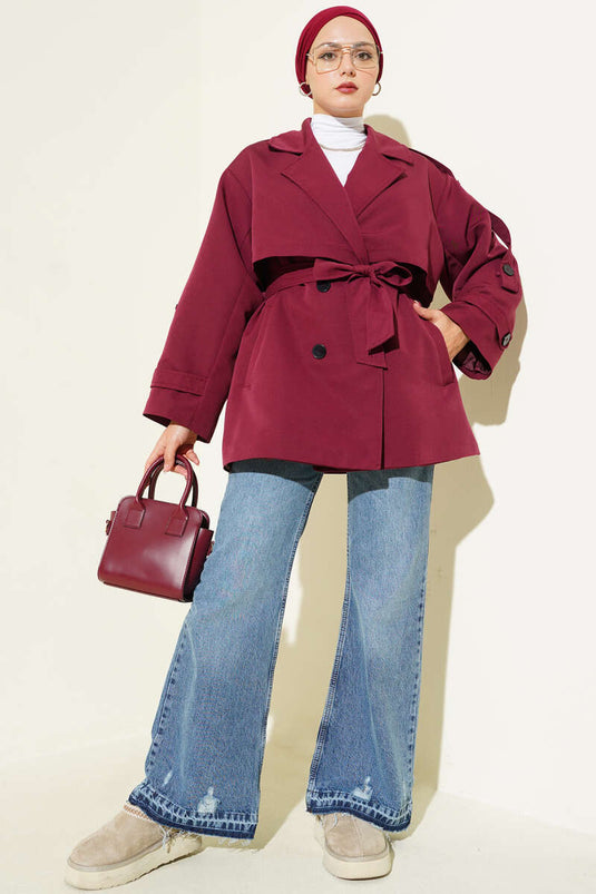 Trench-coat court bordeaux avec cape et ceinture.