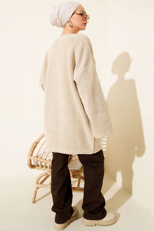 سترة طويلة فضفاضة برقبة دائرية لامعة محبوكة باللون البيج.