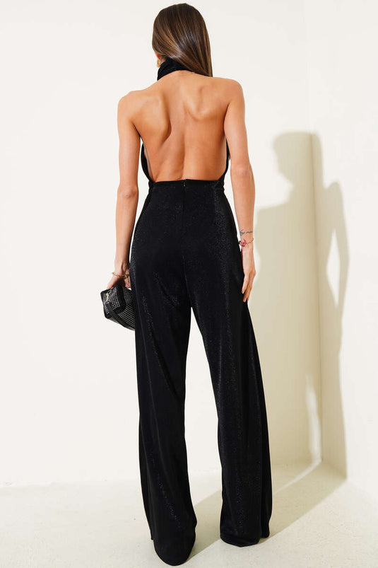 Combinaison noire à paillettes, décolleté et dos nu, ornée de paillettes.