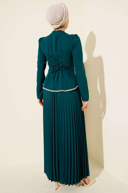 Ensemble deux pièces vert émeraude à jupe plissée et détails en pierre