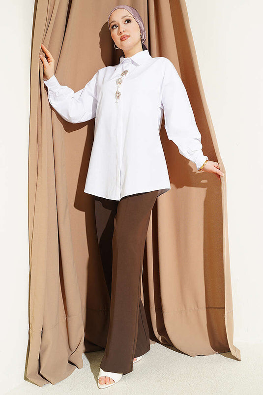 Camicia bianca con bottoni nascosti e spilla con pietre
