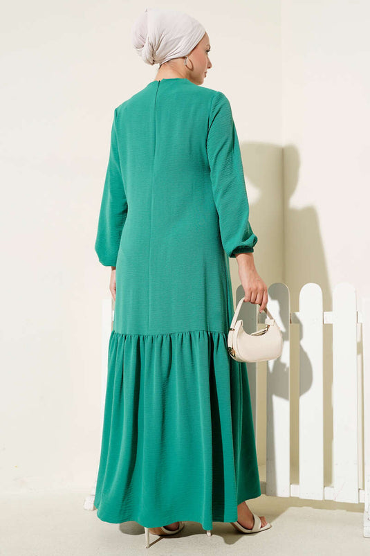 Groene jurk met knoopsluiting en stenen vogeloogdetail