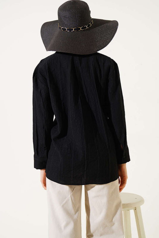 Chemise noire à poche unique et texture froissée