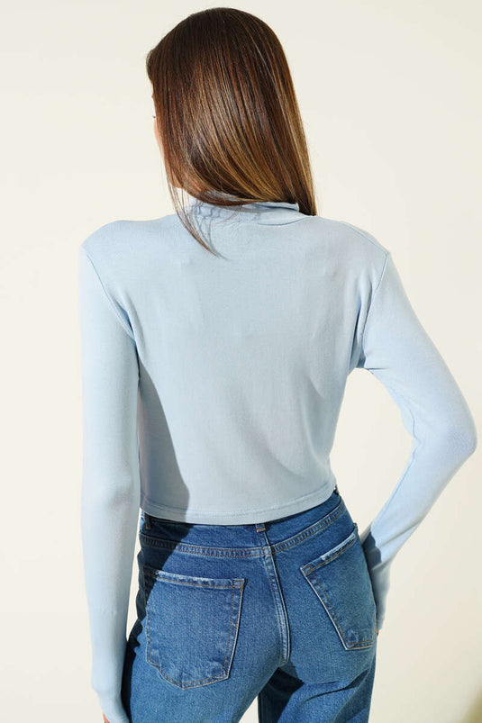 Chemisier bleu à manches longues et demi-zip.