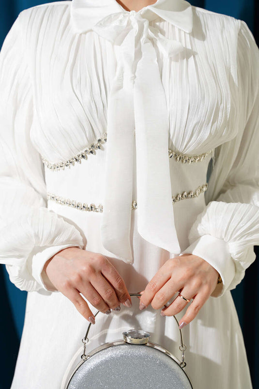 Abito da cerimonia bianco con fiocco e pietre sul collo