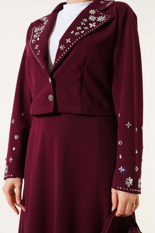 Tweedelig setje met versierde kraag, mouwen en rok in bordeauxrood.