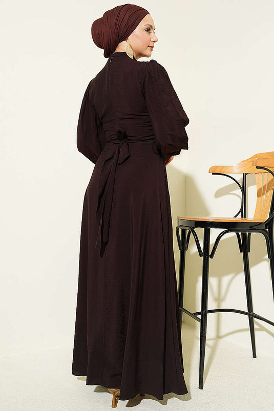 Kleid mit seitlicher Bindung und goldenem Accessoire in Dunkelbraun