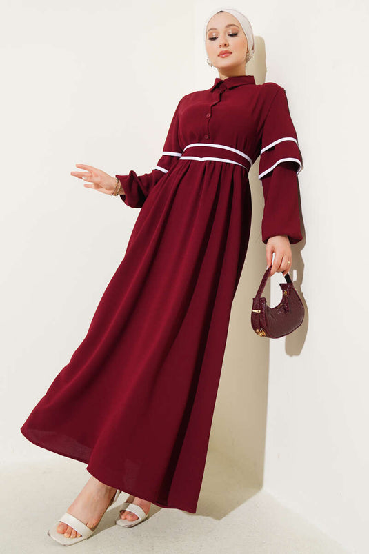 Vestido burdeos con cinturón y medio botón adornado