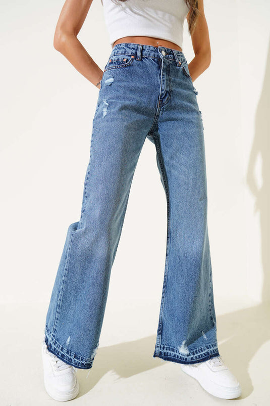 بنطال جينز أزرق بقصة جرس وتفاصيل ممزقة