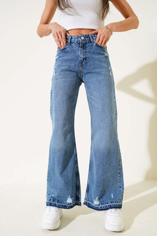 بنطال جينز أزرق بقصة جرس وتفاصيل ممزقة