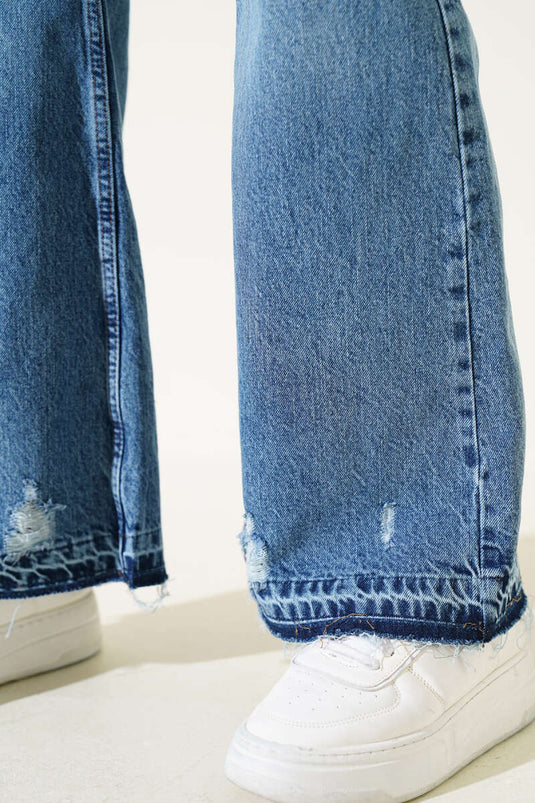 بنطال جينز أزرق بقصة جرس وتفاصيل ممزقة